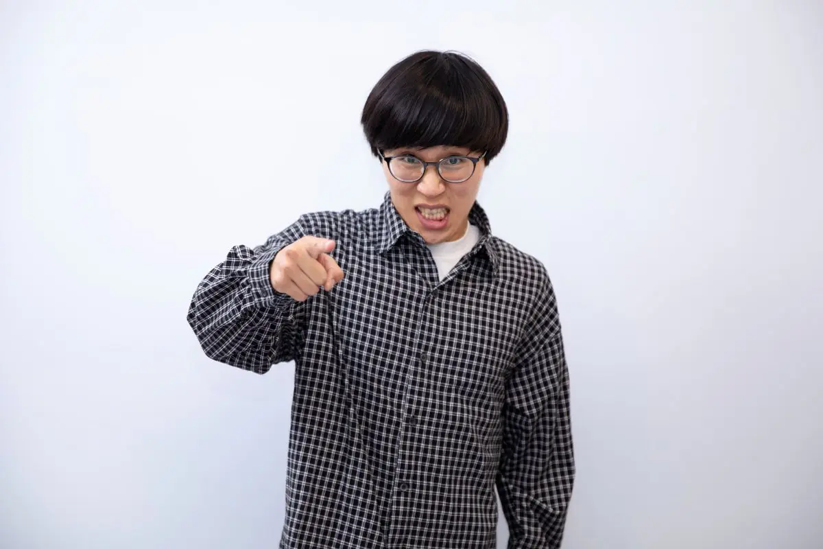 睨みつけるような表情でこちらを指さすたかやさん